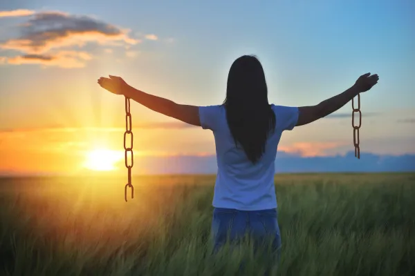 Woman feeling free in a beautiful natural setting, in what field at sunset. Free from chains.