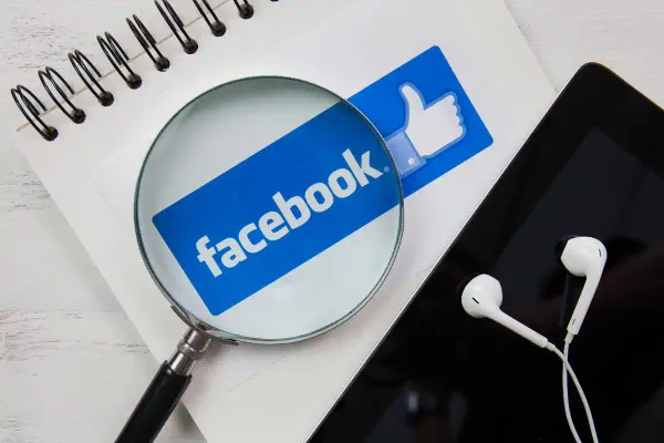 facebook on notebook and magnifying glass
